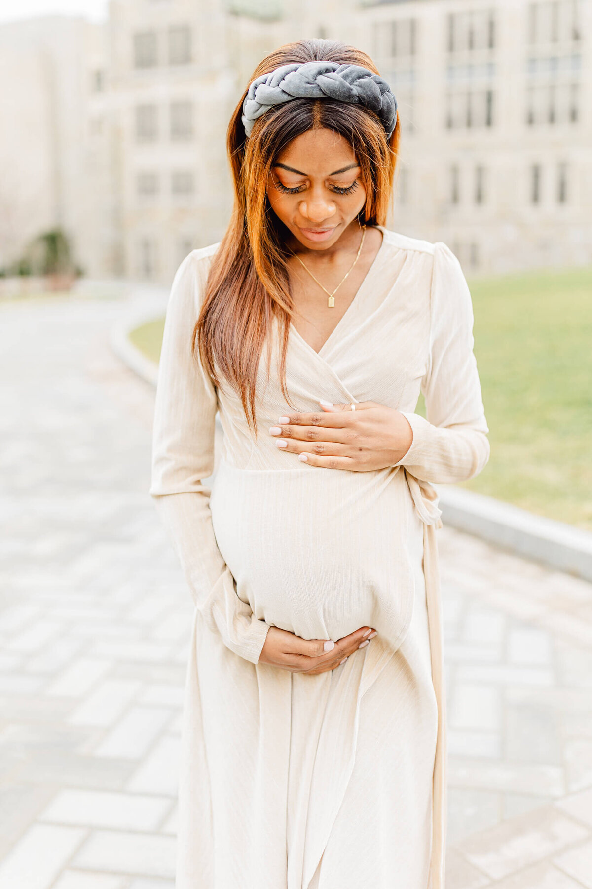 Pregnant mom looks down at her baby bump at Boston College