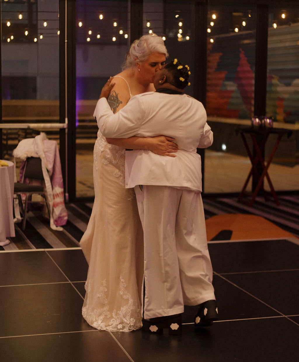 A newlywed couple dancing and kissing.