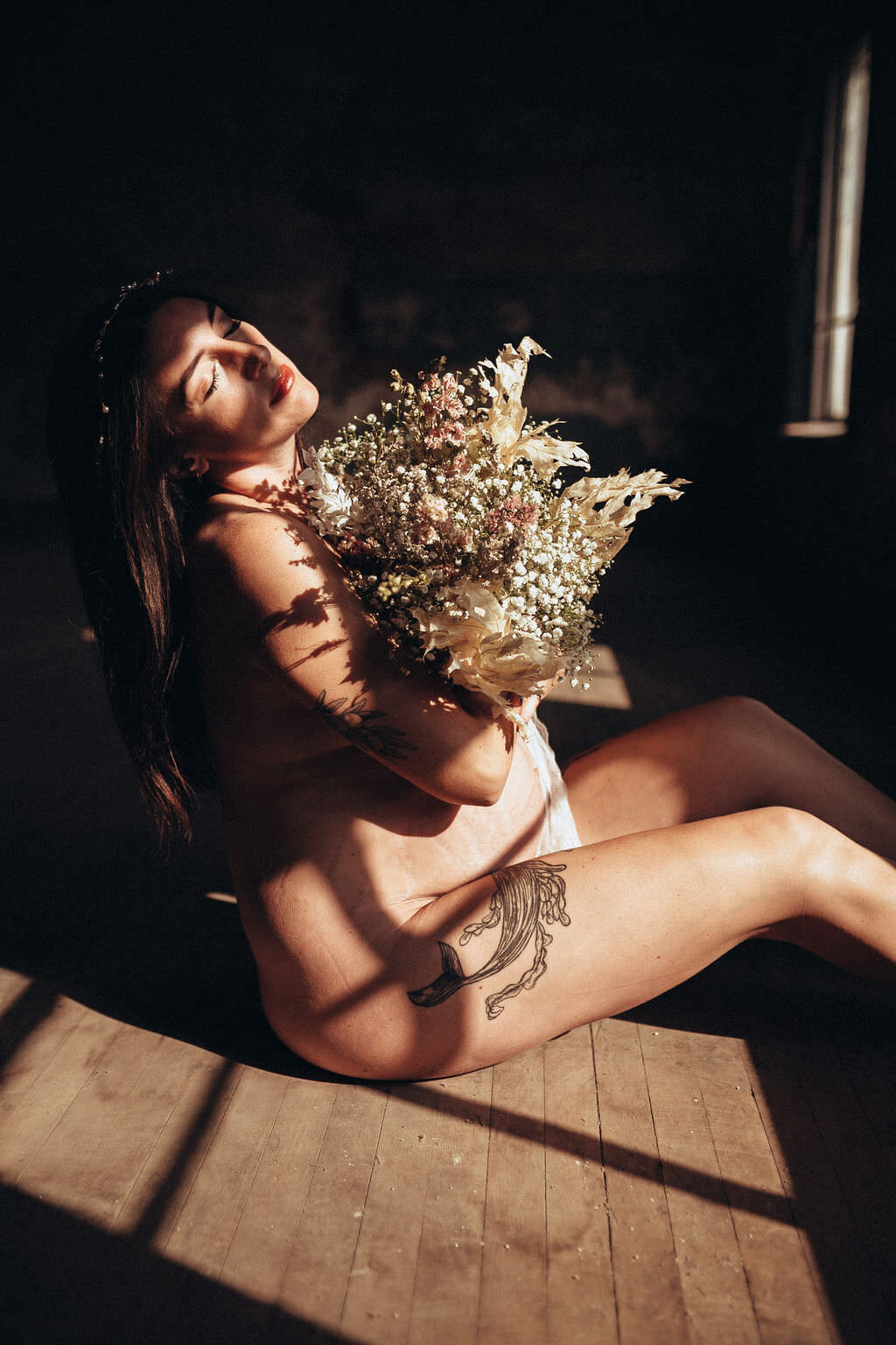 pregnant woman sitting holding flowers posing