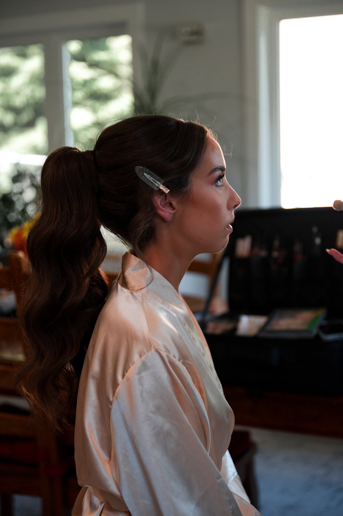 bride getting her make up finished on the day of the wedding 