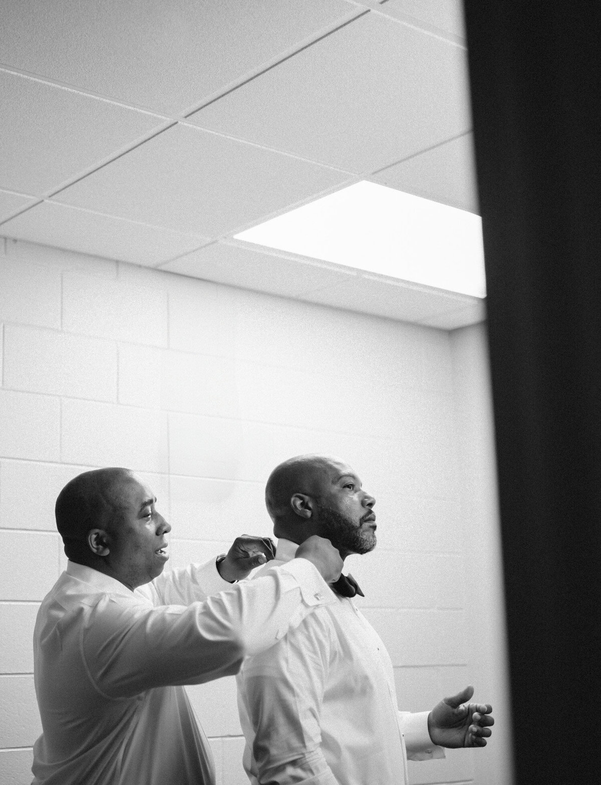 groom is helped with his tie, getting ready for his DIA Detroit wedding