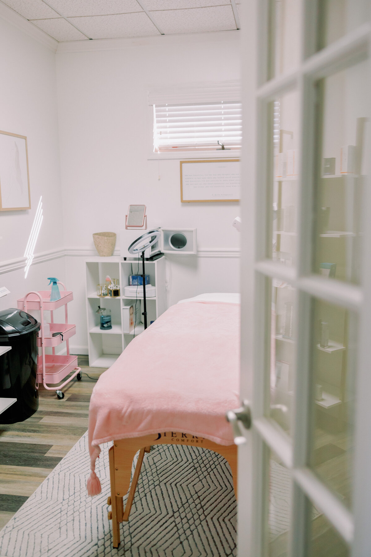 A table at a salon has a pink tablecloth on it.