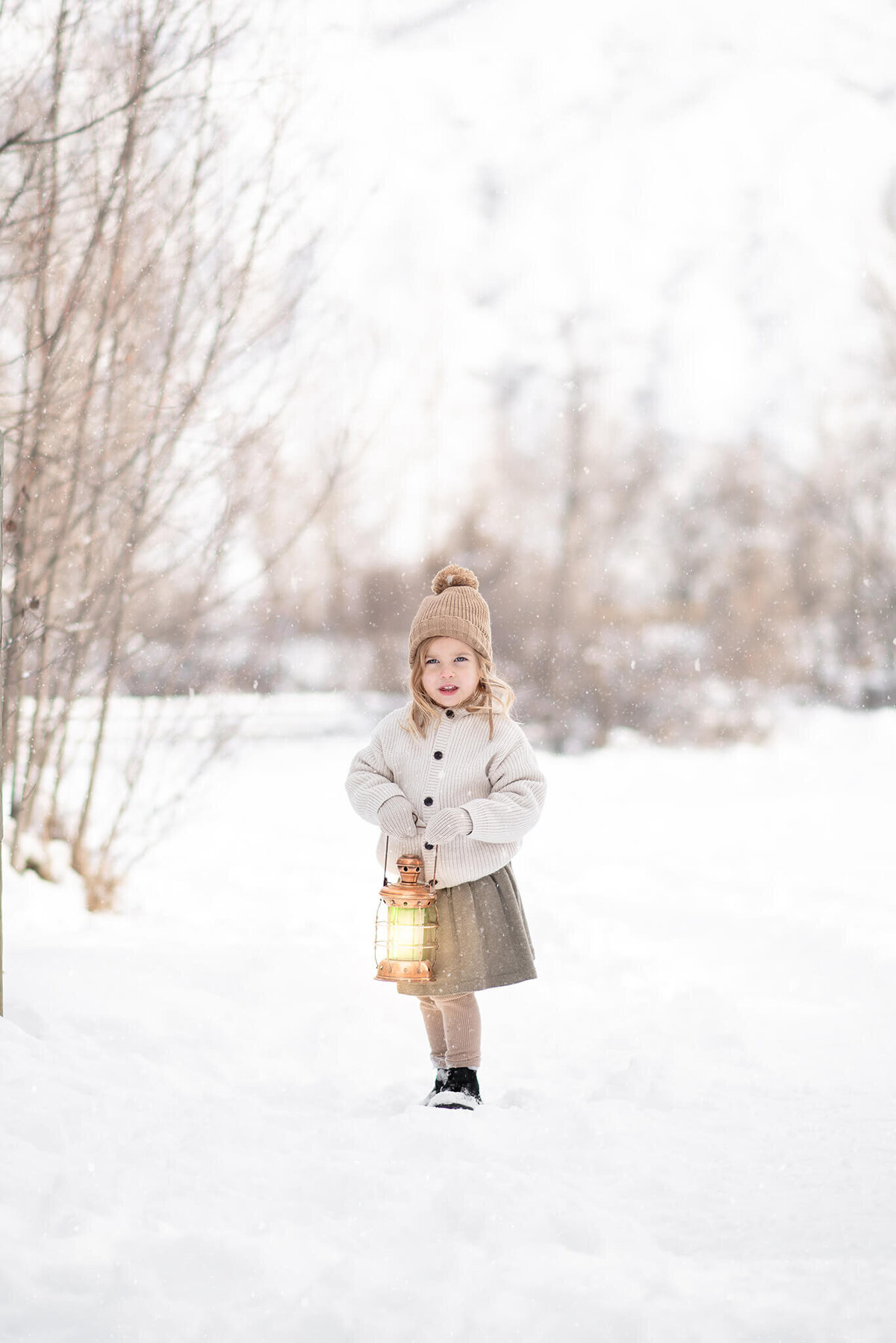 Little girl in the winter in the snow holding a glowing lantern, in Kamloops. Captured by Brittany Danielle Photography