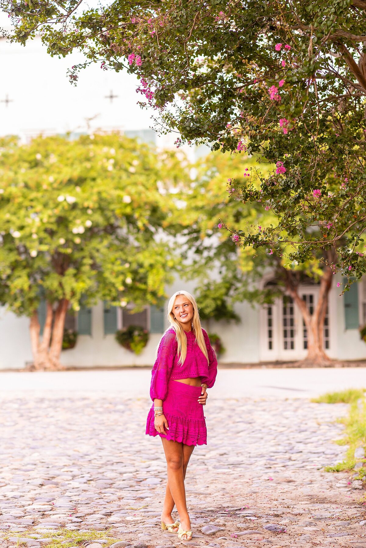 High school senior posing at Rainbow Row, Charleston, SC, in light-filled, authentic portraits