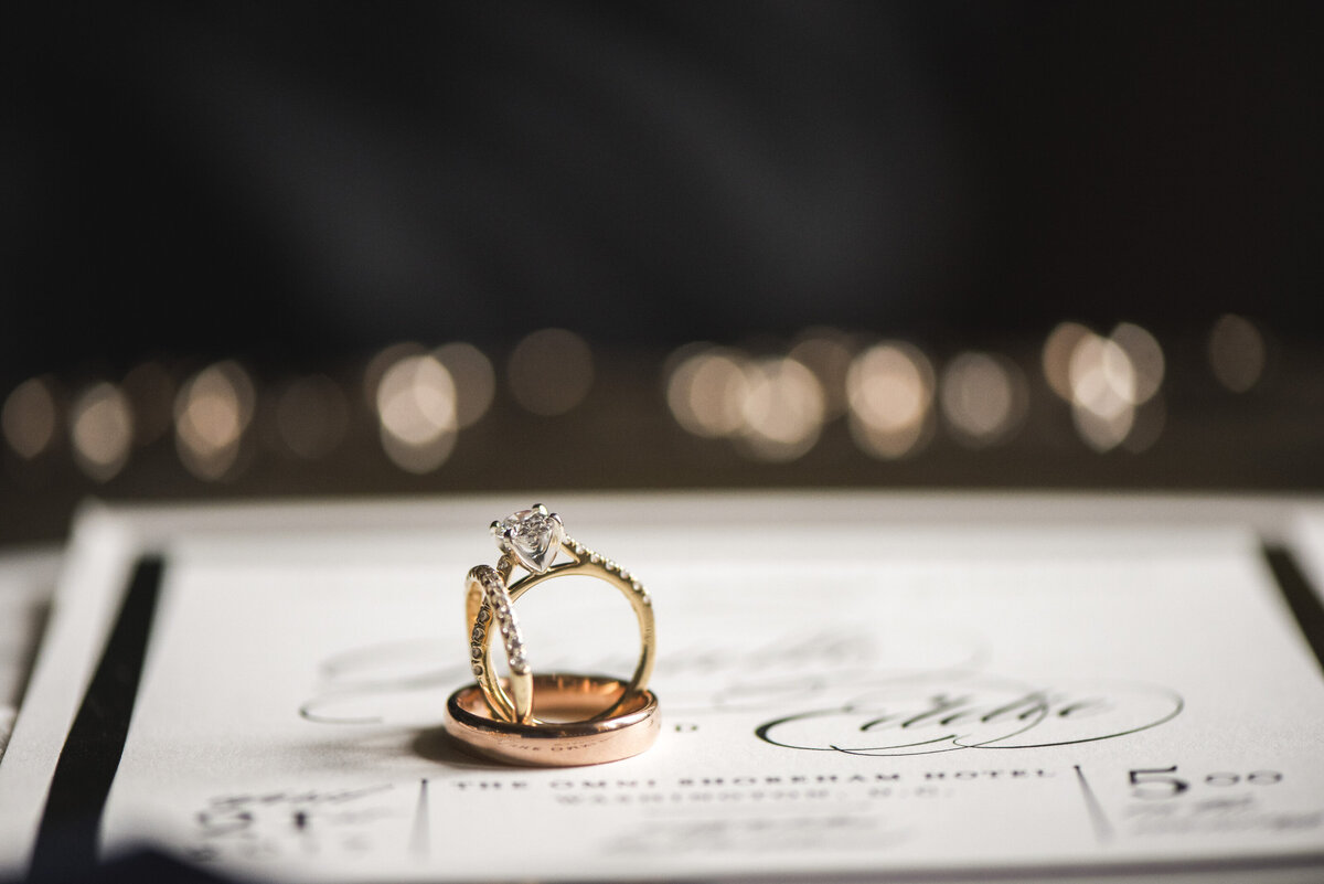 Wedding and engagement rings stacked together on a table 
