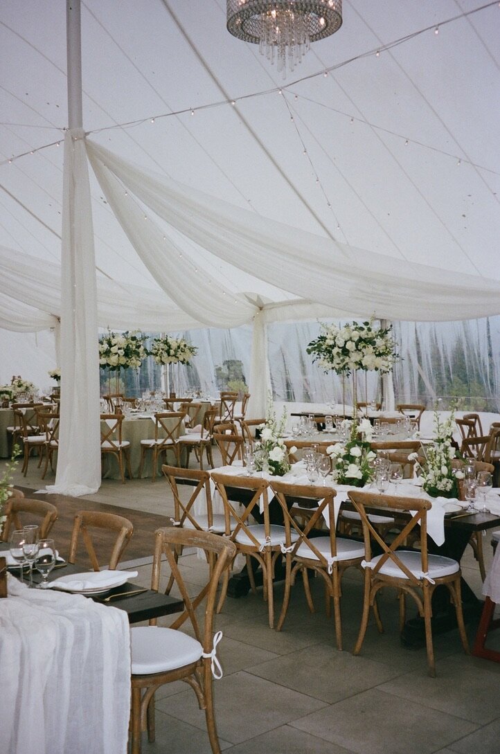 tent wedding, chiffon drapery, sage greenery, tall arrangements, eucalyptus, gold stands, tie knot napkin, crossback chairs, farm tables, cheese cloth