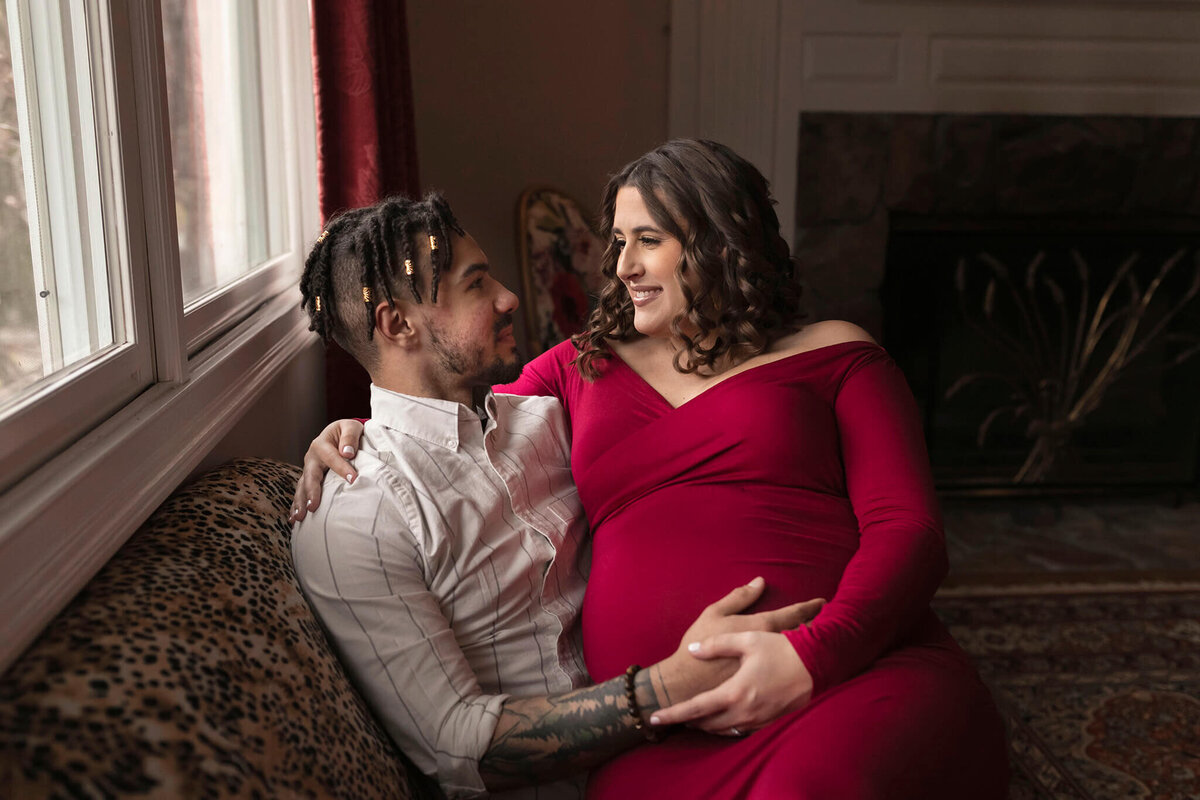 NJ Maternity photography session of parents to be cuddled on couch