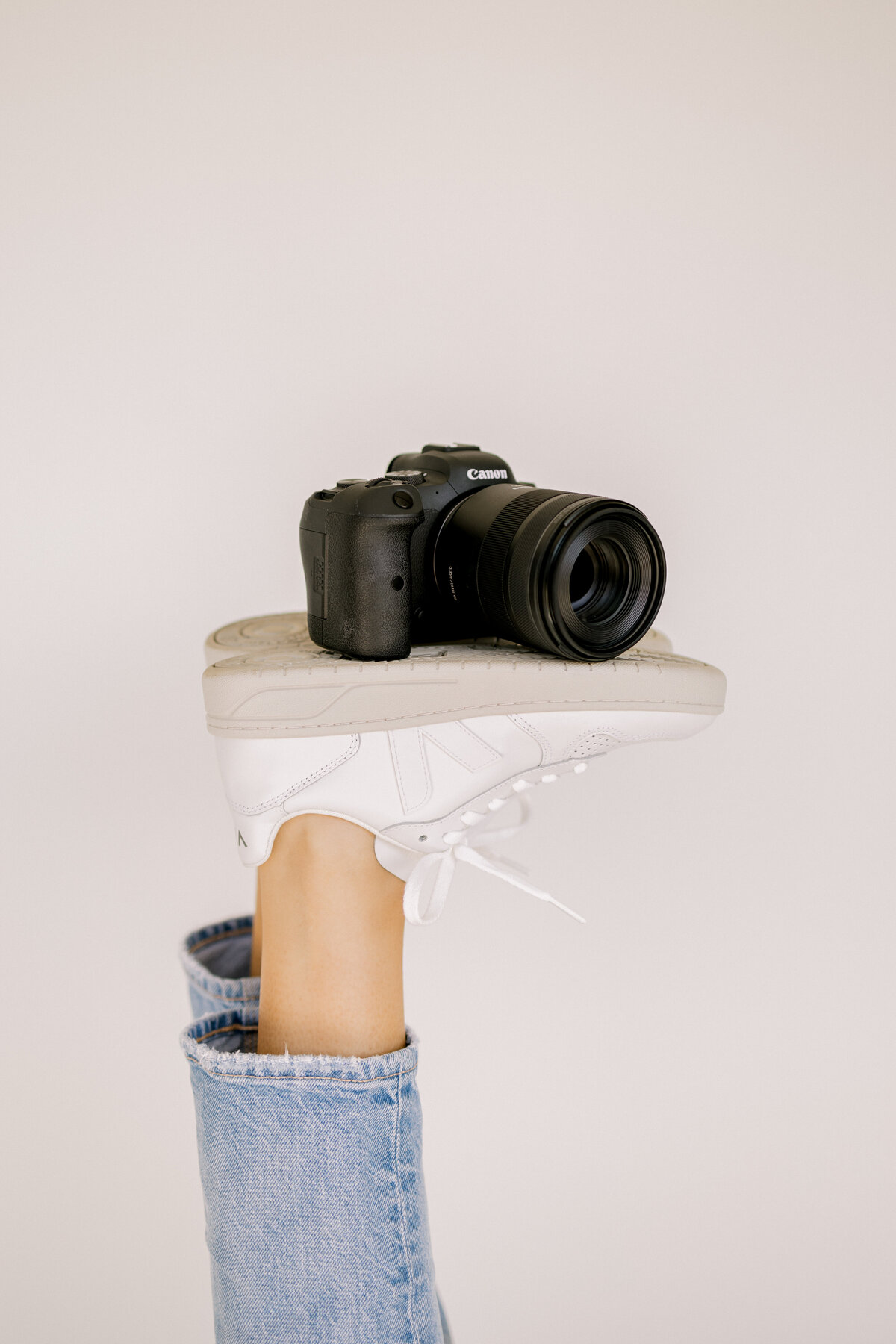 a pair of veja tennis shoes with a camera sitting on them