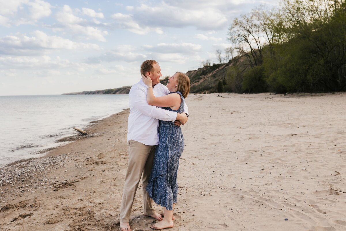 Husband and wife embracing while dancing on the beach