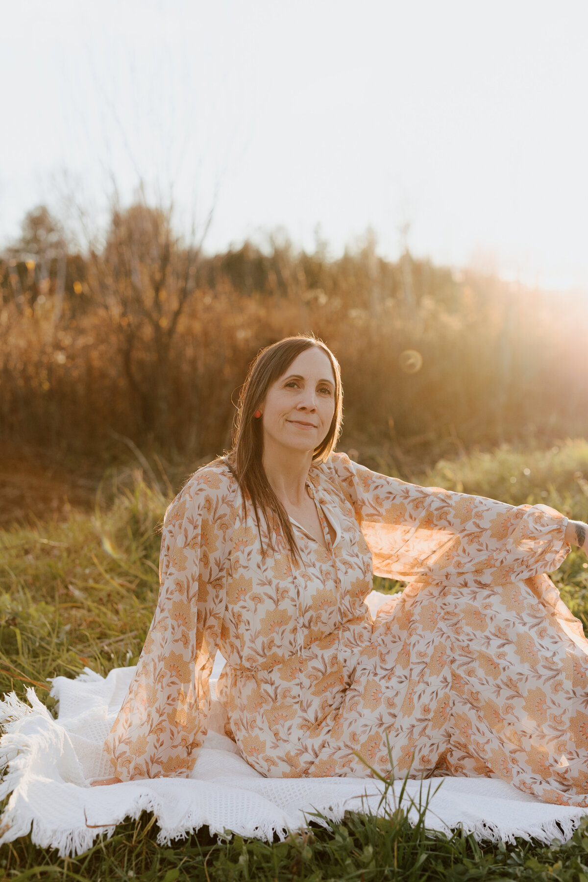 Julie sitting at a picnic mat as she poses for the camera