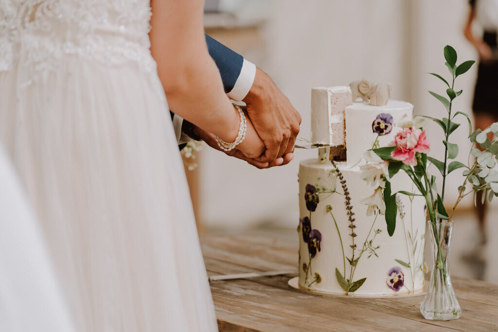 Fun spring-inspired white two-tiered textured wedding cake surrounded with edible dried florals, created by Chartier YYC, elegant cakes & desserts in Calgary, AB, featured on the Brontë Bride Vendor Guide.
