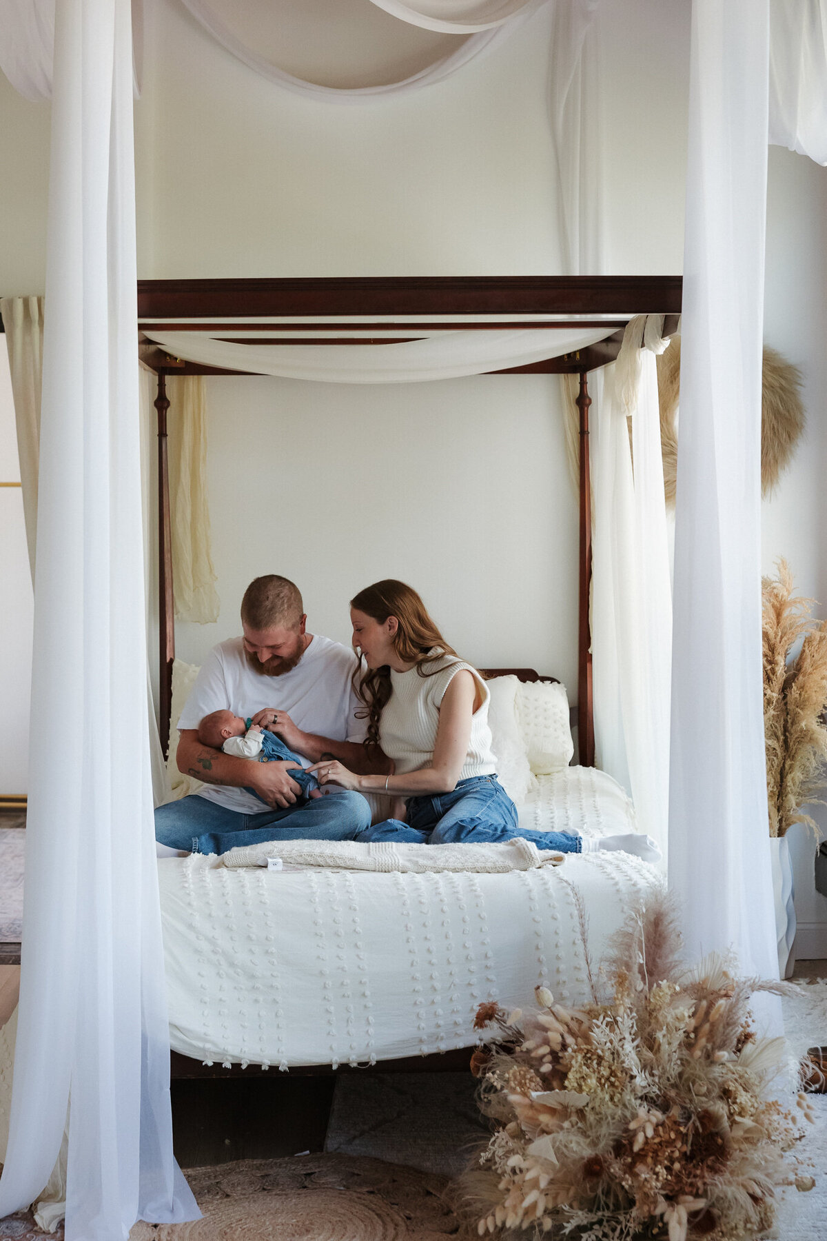 Vermont Home Newborn Photographer | Sincerely Liz Photography Documentary Wedding, Engagement, Elopement, Maternity and Newborn Photographer in New England | Couple holding their newborn while sitting at bed