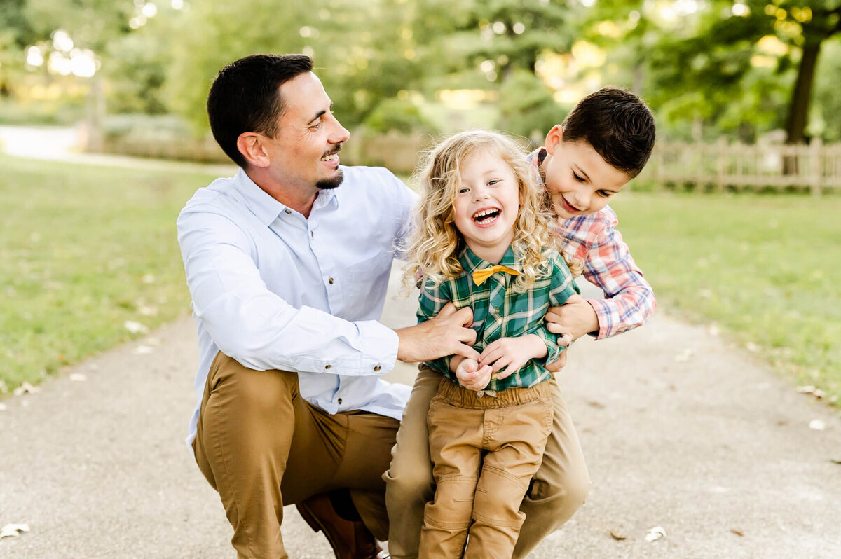 A father and his sons  relaxed and laughing at family session near Naperville, IL.
