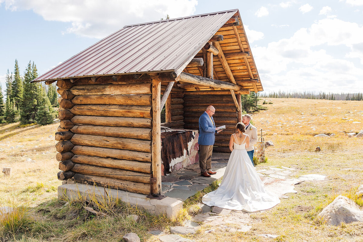 Bride and groom exchanging vows during their elopement ceremony at the St. Albans Chapel in the Snowy Range Mountains.