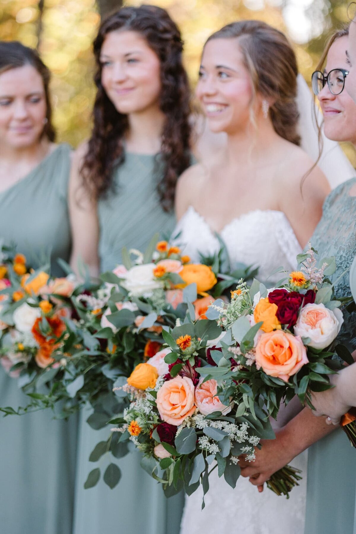 Bride and bridesmaids smiling and holding bouquets at farm wedding near Charlottesville VA