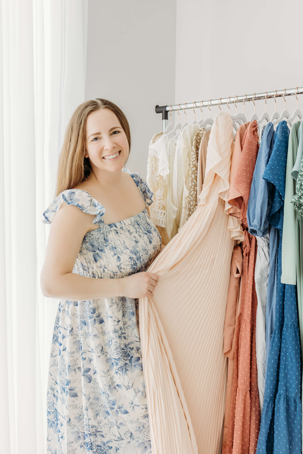 Woman showing off beautiful garment rack and wardrobe for the whole family