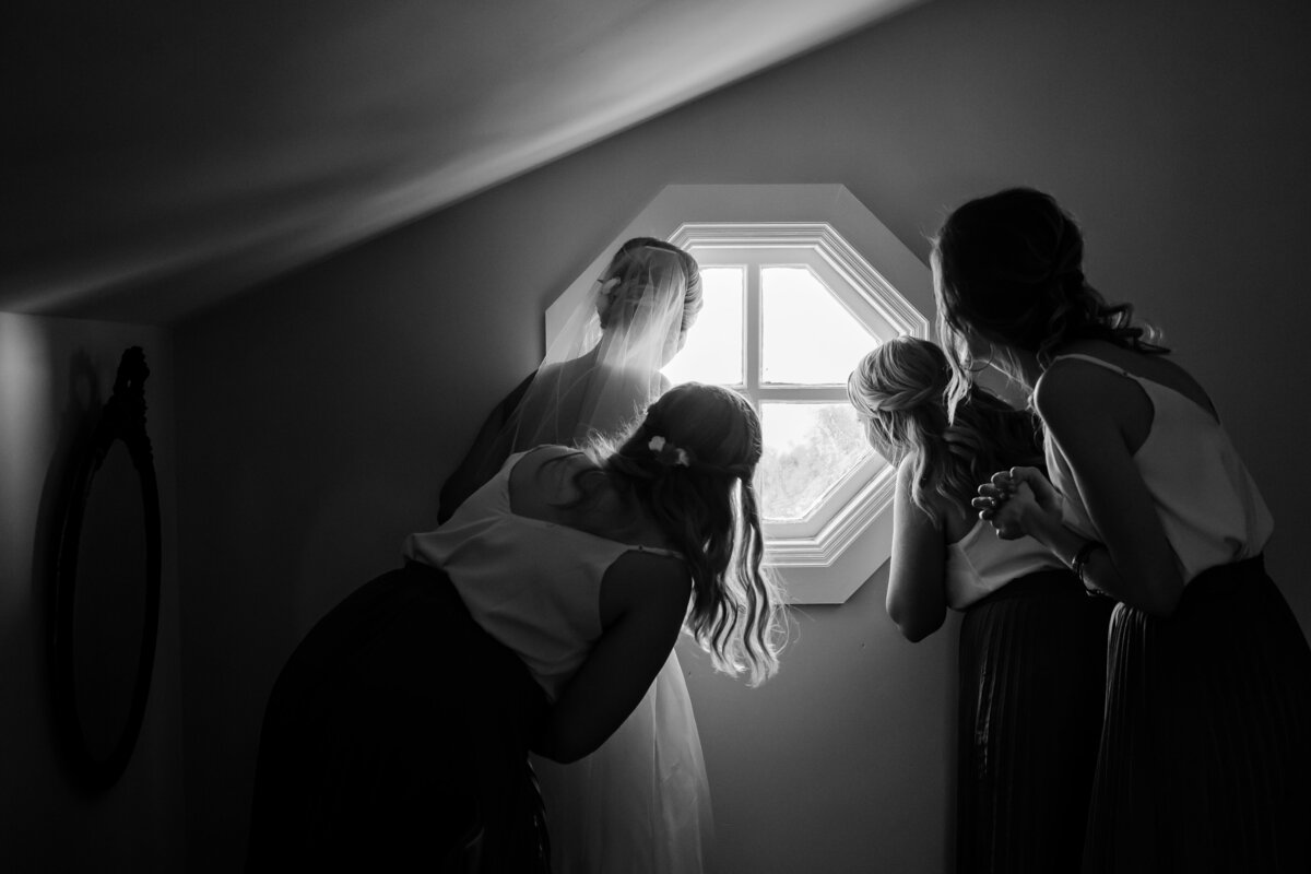 Bride and her Bridesmaids peek out a window at the ceremony guests in Palmetto, FL