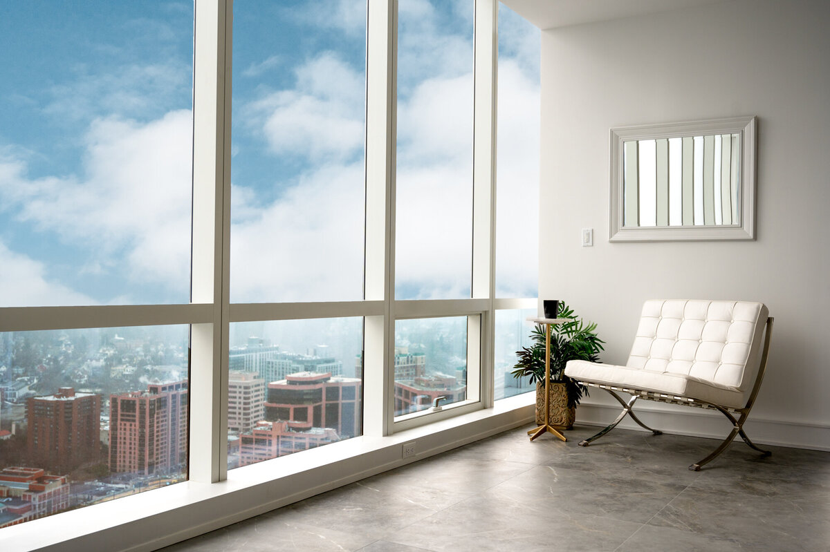 Sitting area with white chair and tall windows