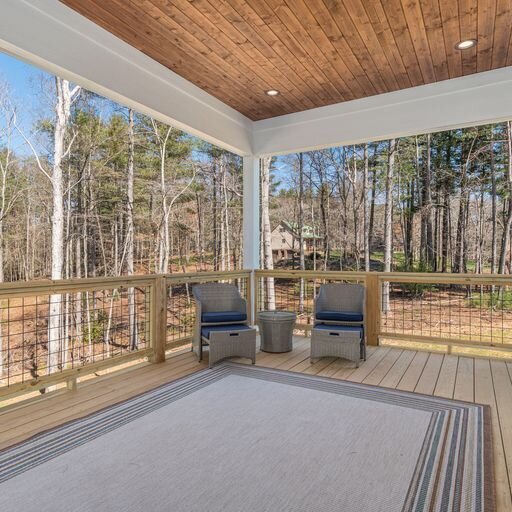 A covered porch with a view of the woods