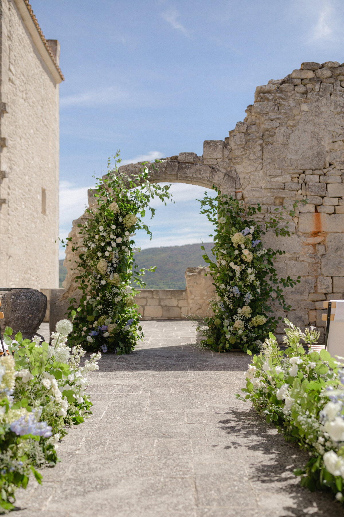 Floral arch outdoor wedding ceremony