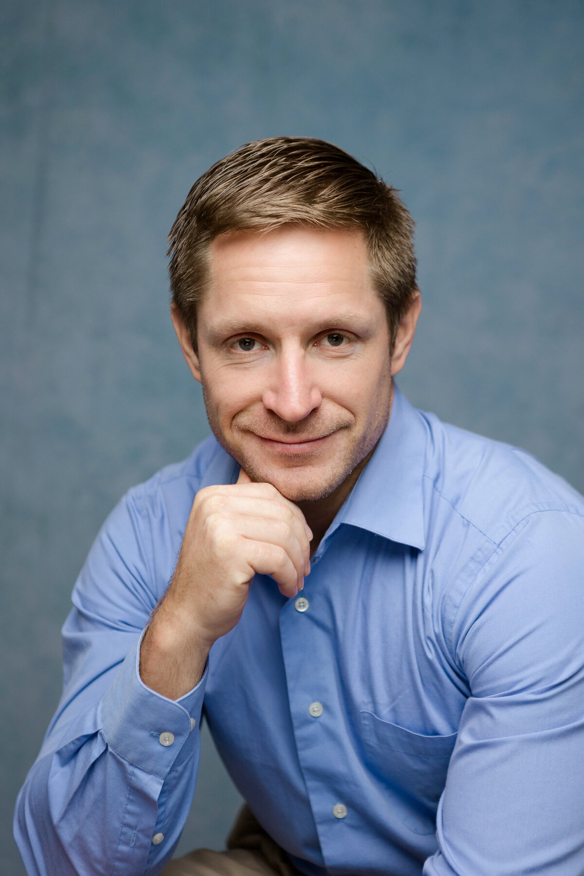 Headshot of a man in a blue button down shirt