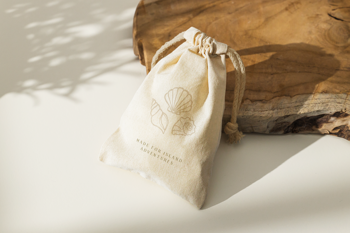 Linen bag with elegant, natural branding leaning against a piece of wood