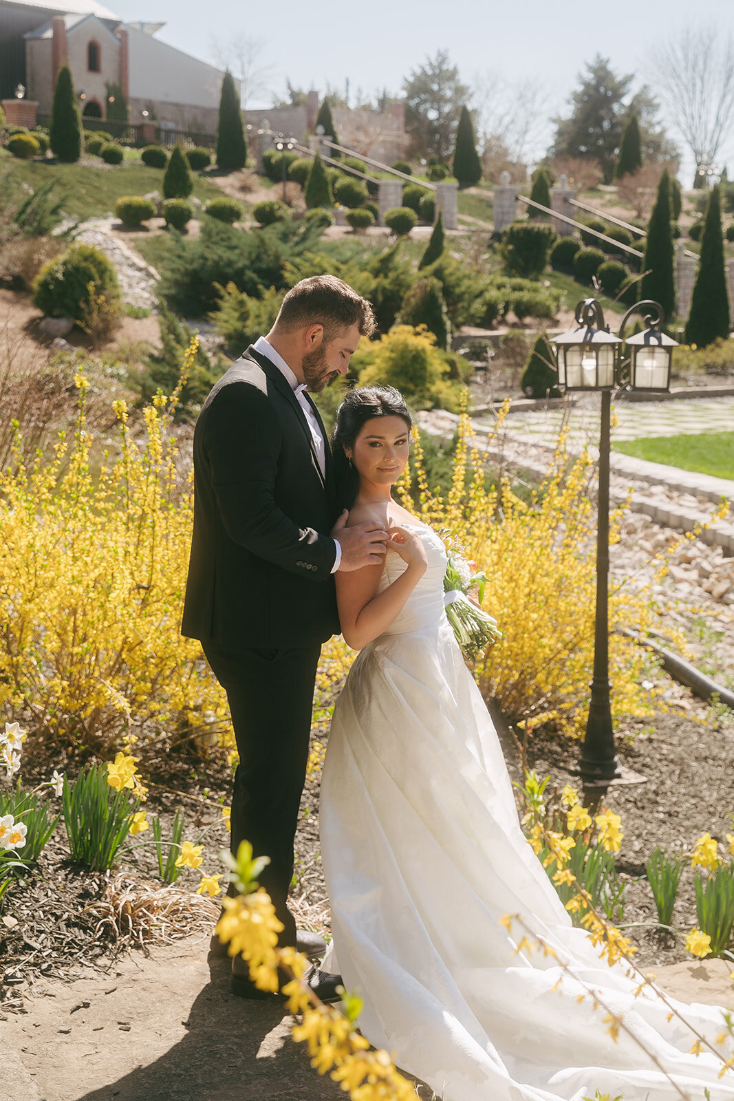 A bride and groom standing in front of yellow wildflowers at their venue in Nashville. 