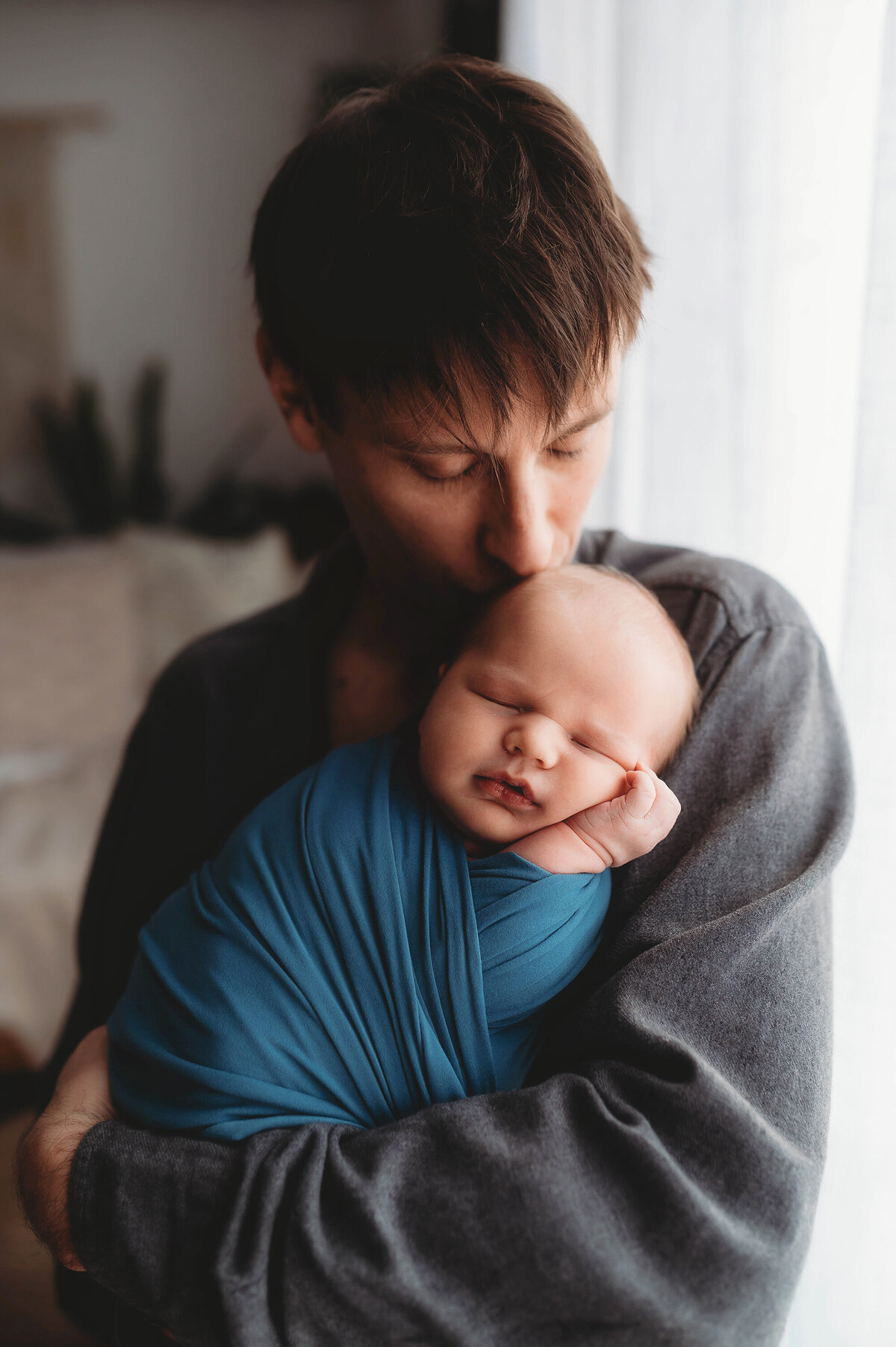 Father embraces his son during Newborn Portrait Session in Charleston, South Carolina.