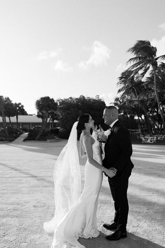 A beautiful scene of the bride and groom walking together along the sandy shore, enjoying their first moments as husband and wife. Destination wedding photography by Claudia Amalia Photography in the Florida Keys.