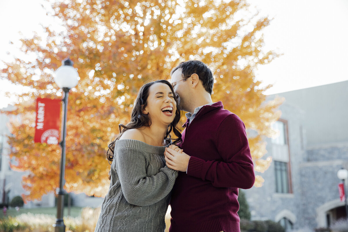 Laughing couple holding hands during summer engagement shoot at Marist College campus in Poughkeepsie New York