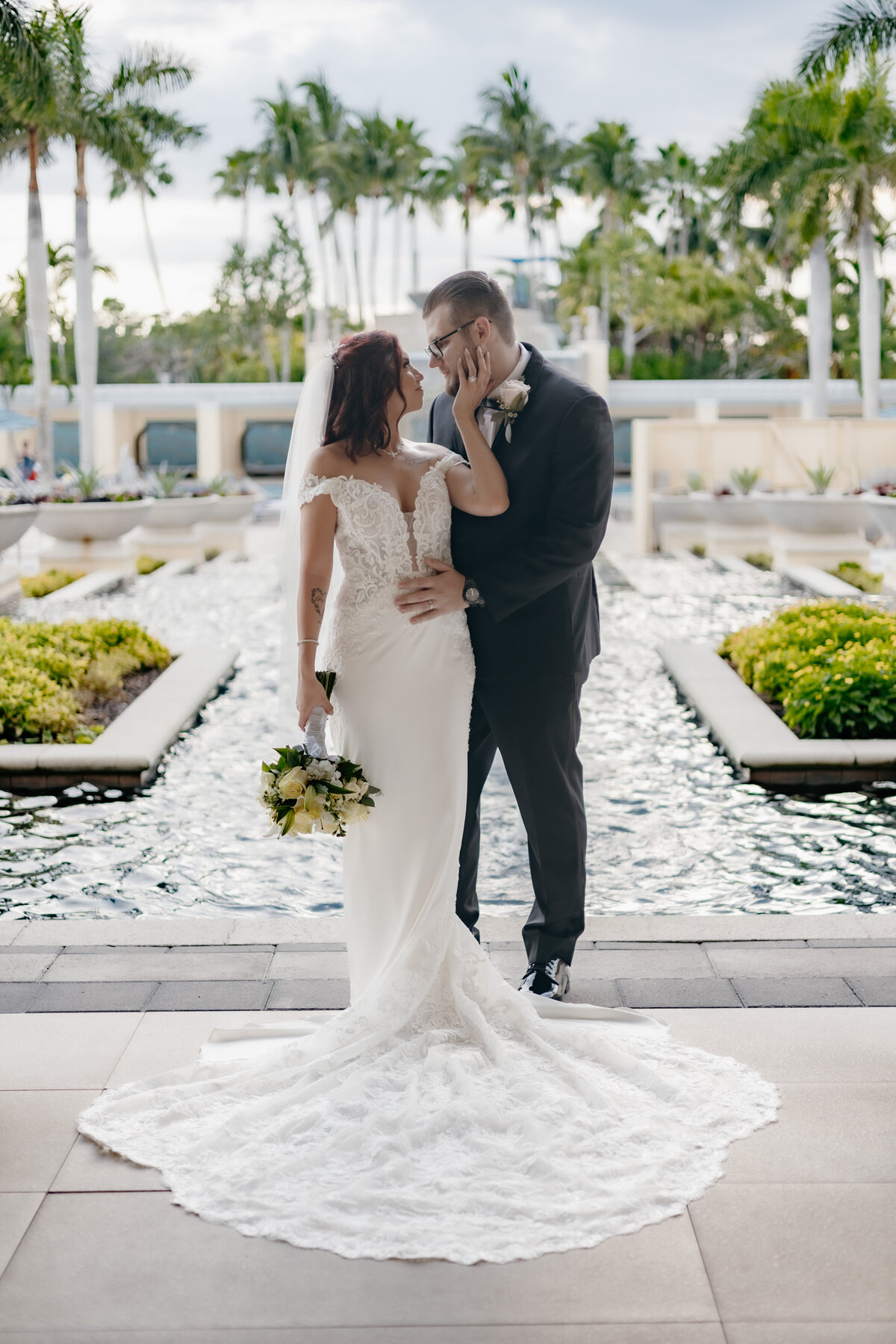 Bride and groom posing in front of fountain at Hyatt Regency in Estero