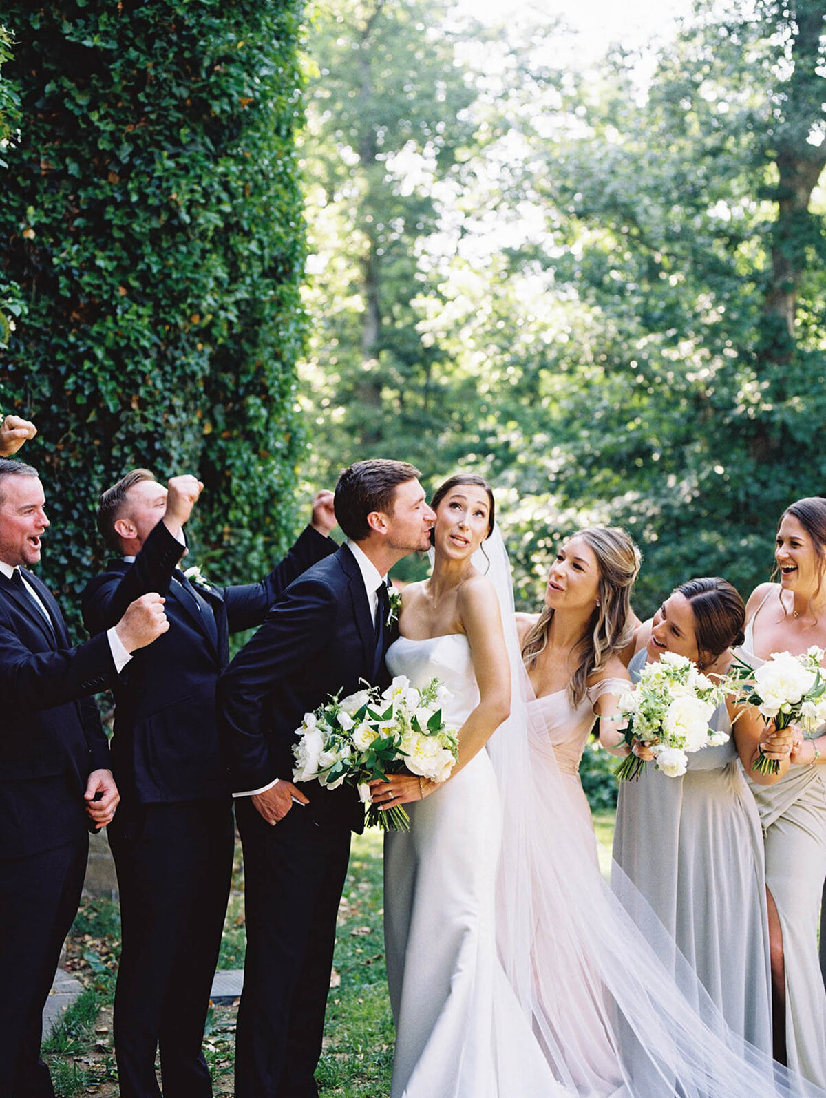 Groom kisses bride and bridal party celebrates