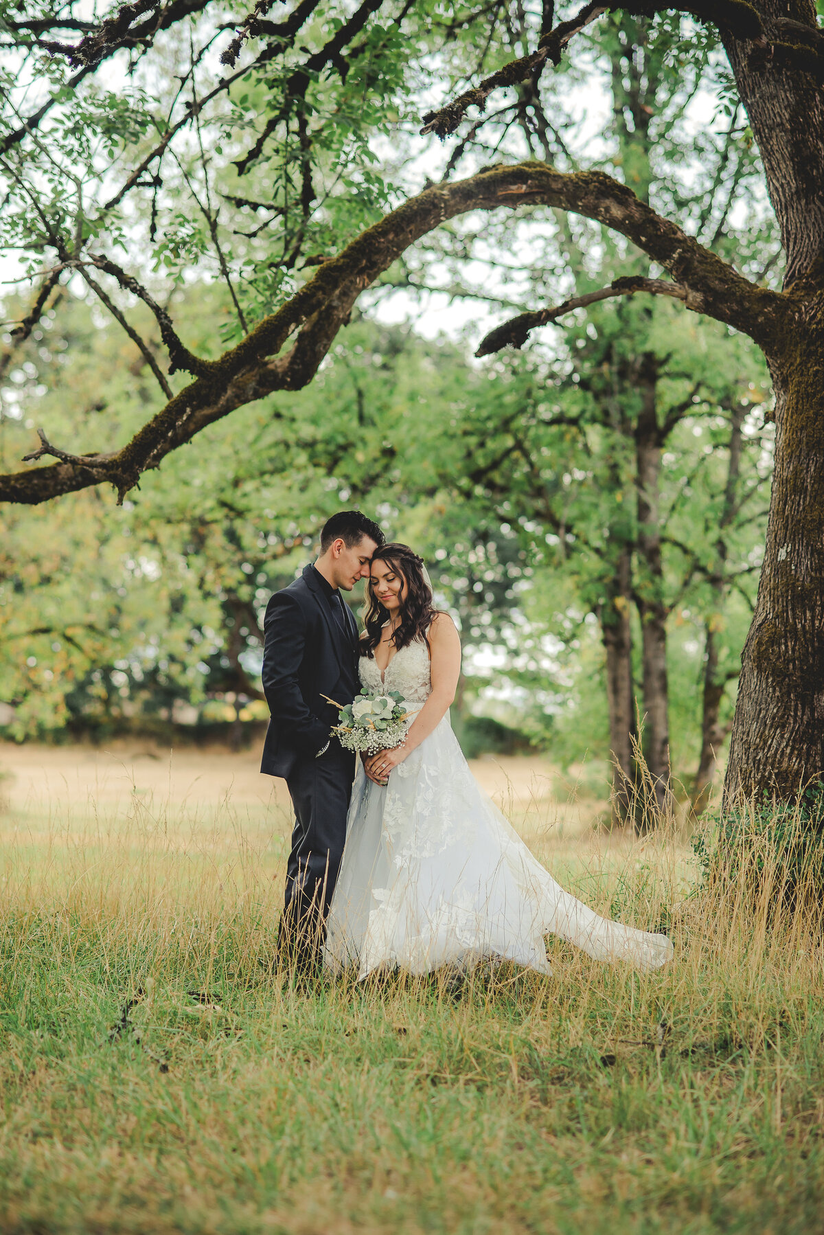 bride and groom under tree
