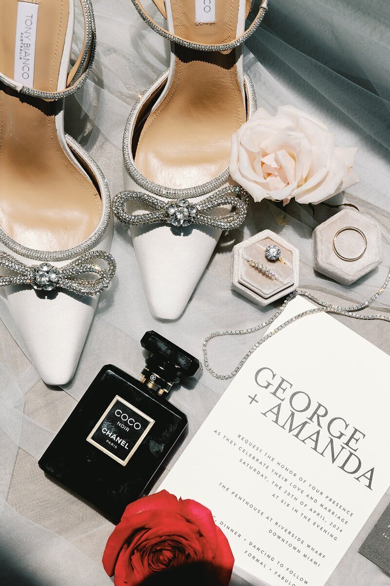 wedding details including perfume, invites, and rings at penthouse at riverside wharf wedding