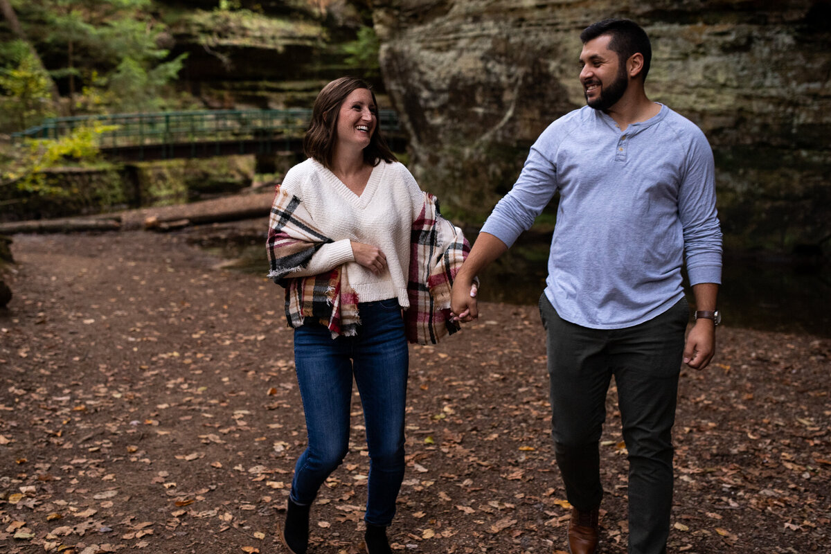Couple runs toward the camera during their engagement session in Hocking Hills