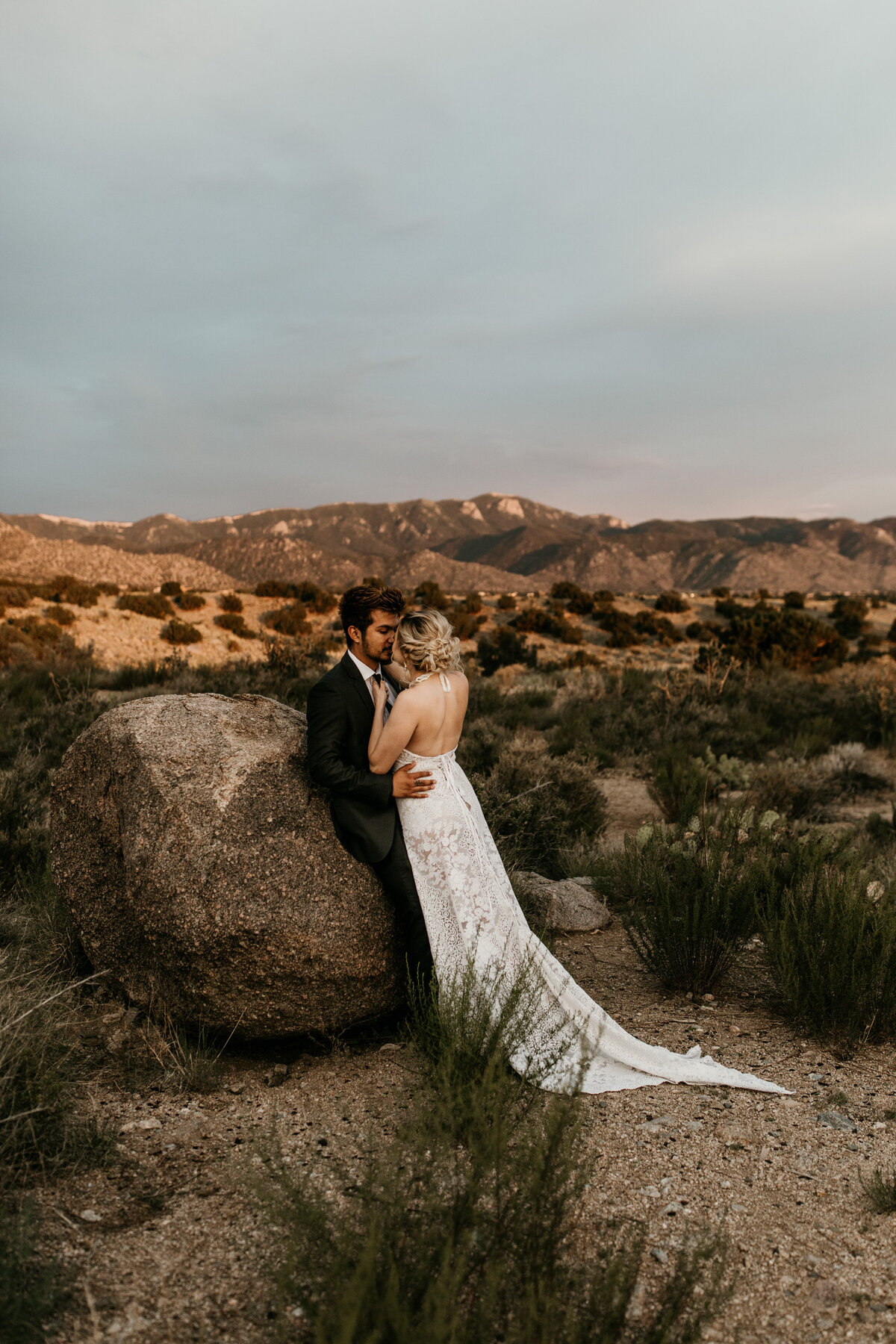 bride leaning on groom in the Albuquerque desert mountains