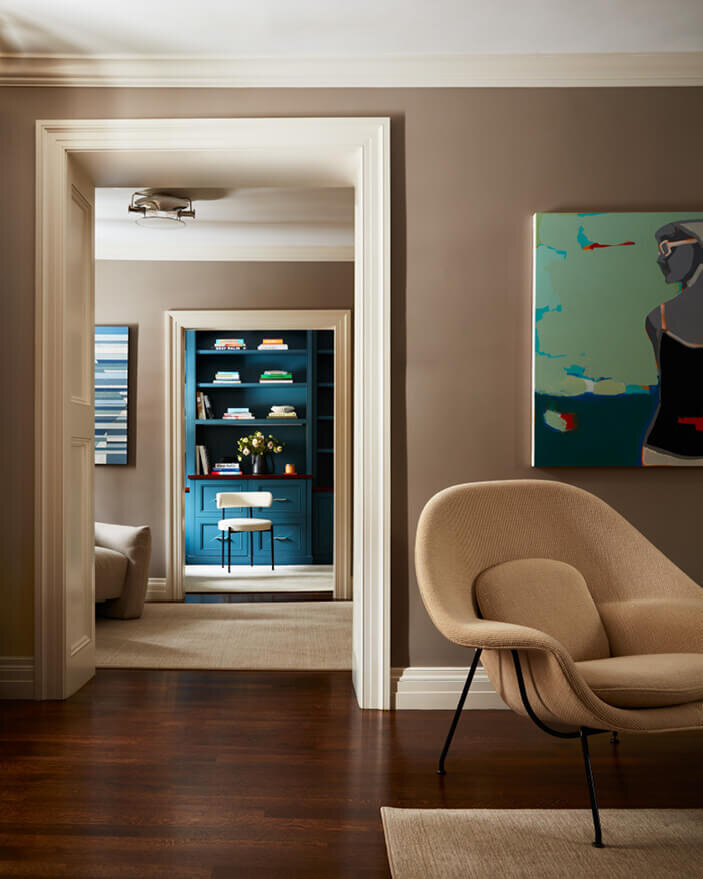 Interior designers in Boston create a mid-century modern bedroom with a statement chair, blending classic architecture with contemporary style.