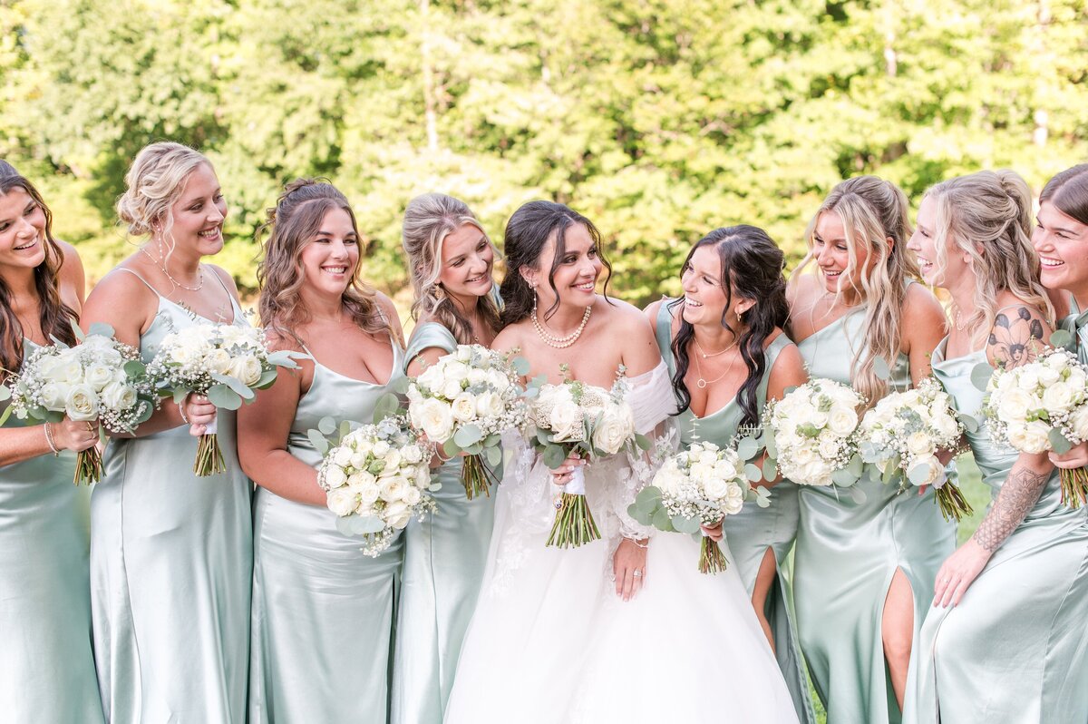 bridesmaids on golf course wearing sage green satin dresses