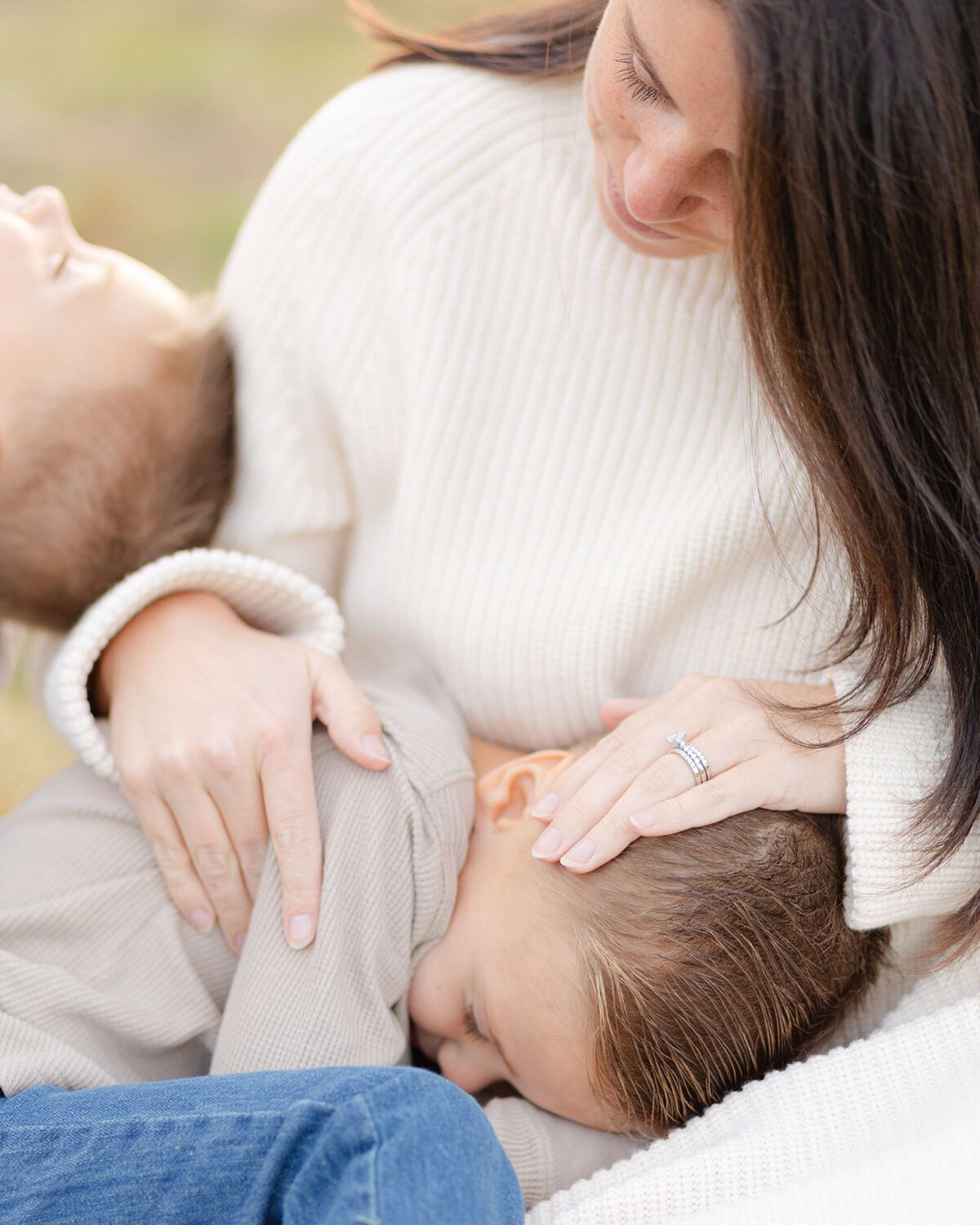young boy lays in mom's lap during boston photography session