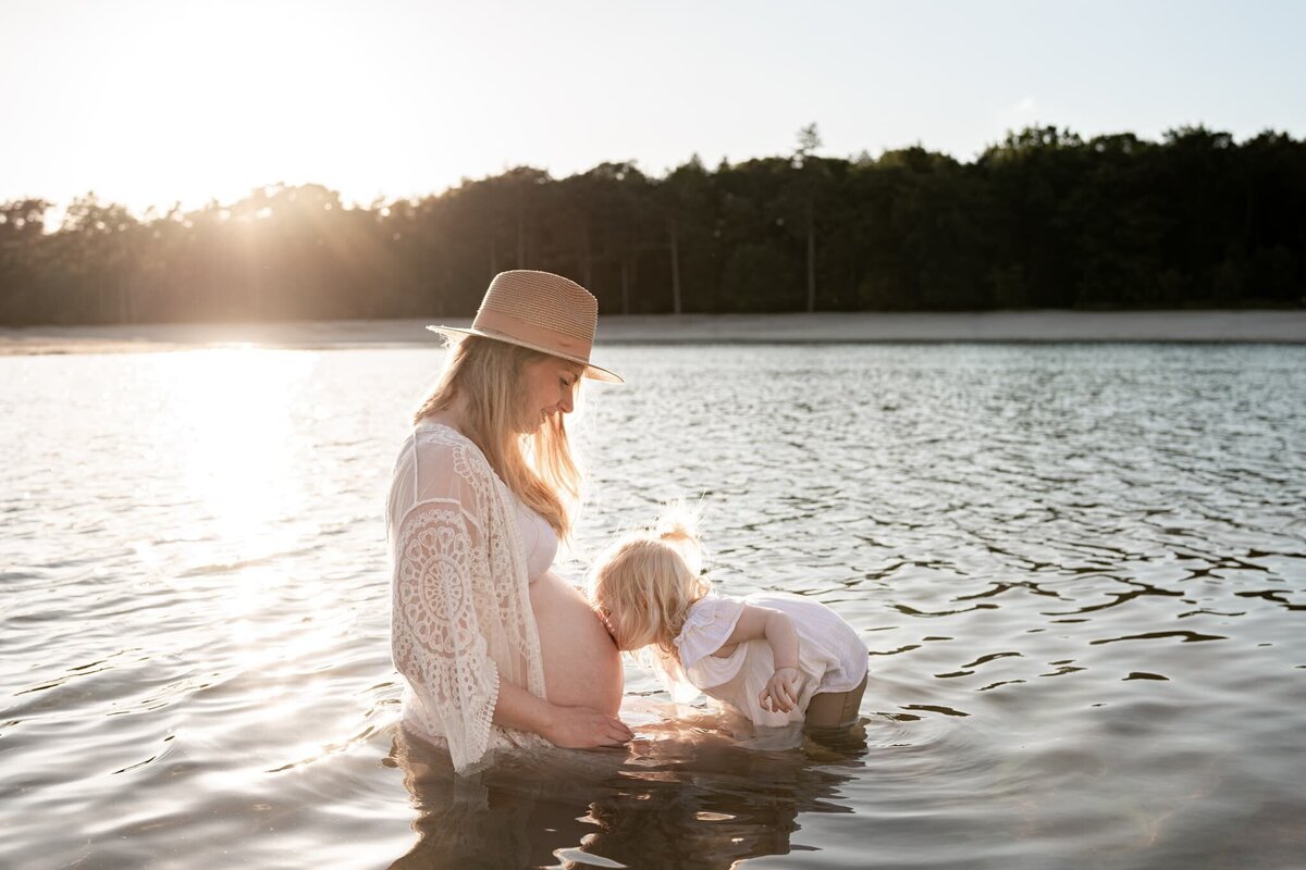 zwangerschap fotoshoot Drenthe - dromerige foto zwangere moeder en kindje in het water.