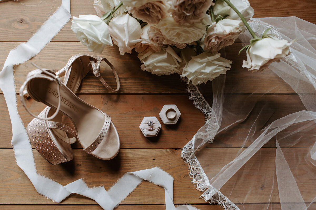 Bridal accessories including her shoes,ring and bouquet.