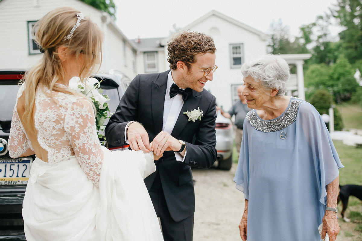 Grandma overlooking the groom putting on a family bracelet on his bride.