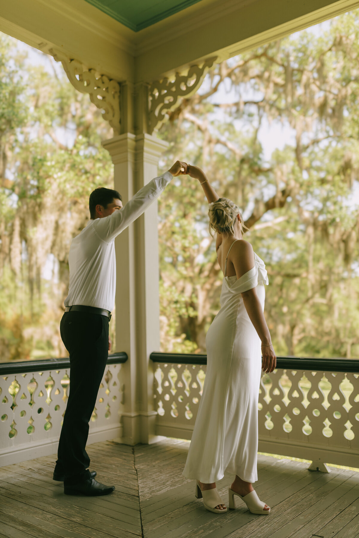 A couple dancing together on the porch of the Jefferson House at Rip Van Winkle Gardens.