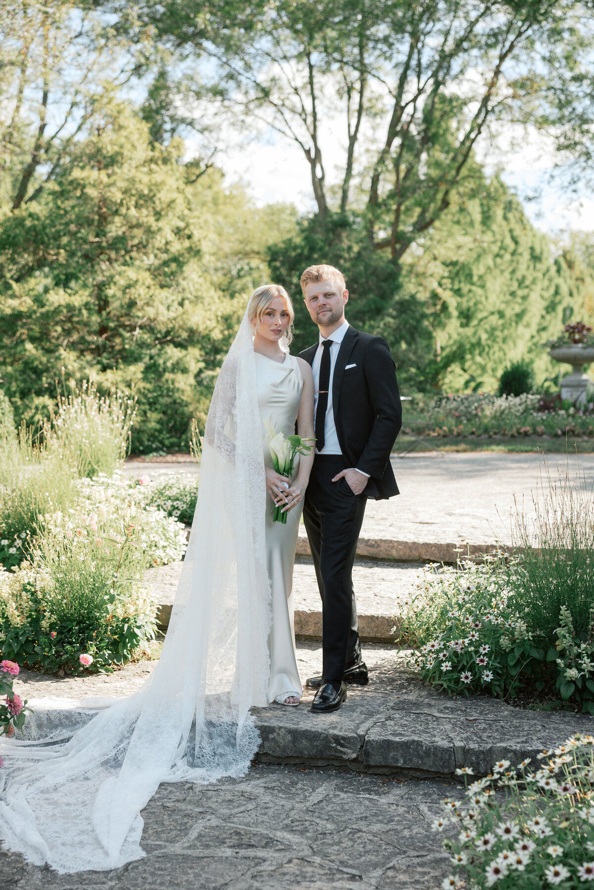 Bride and groom stand in garden at Dayton wedding, captured by Philadelphia-based wedding photographer.