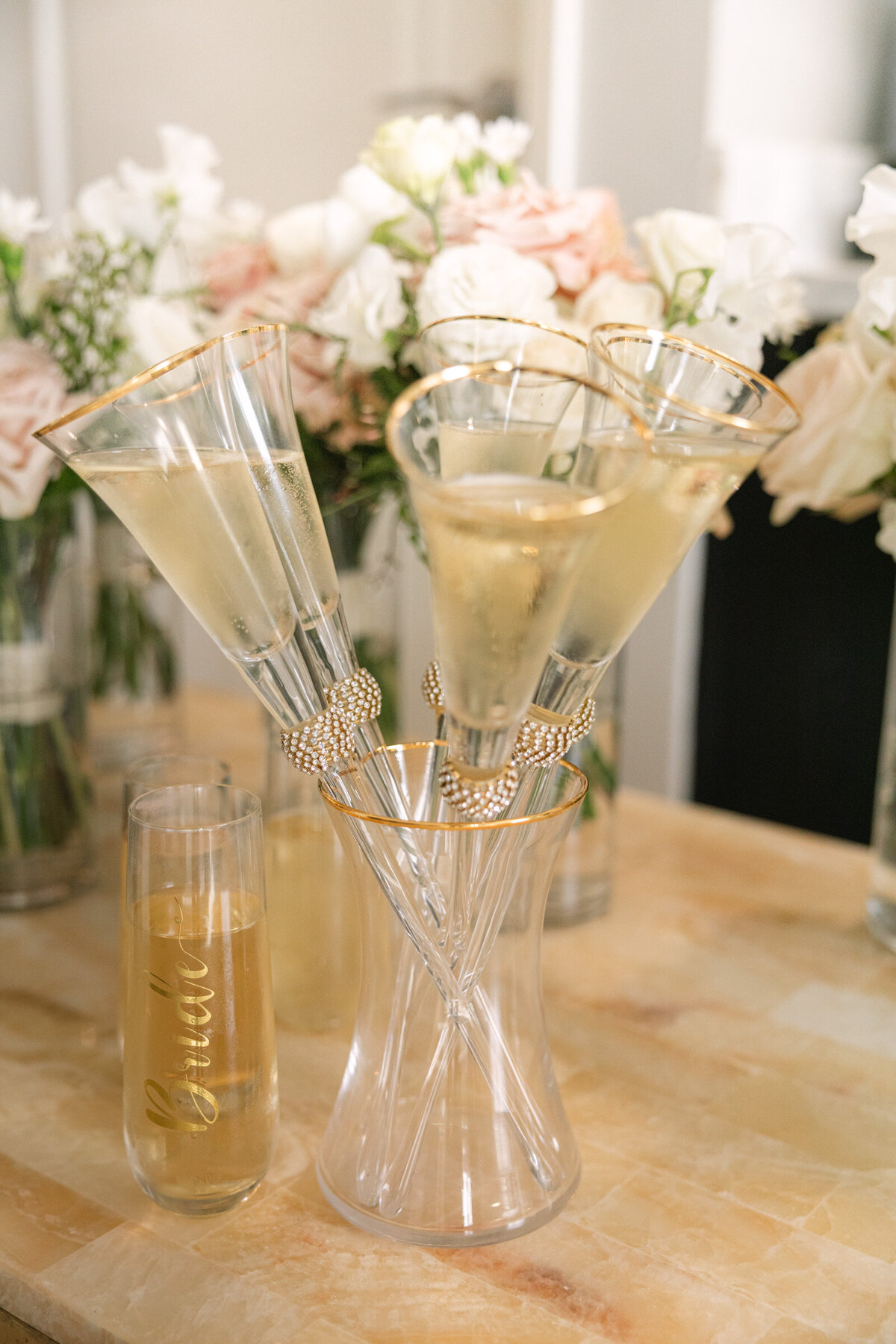 close up of stemmed champagne glasses resting in a vase at a wedding reception at The Adolphus in Dallas, showcasing elegant table styling and unique drink presentation.