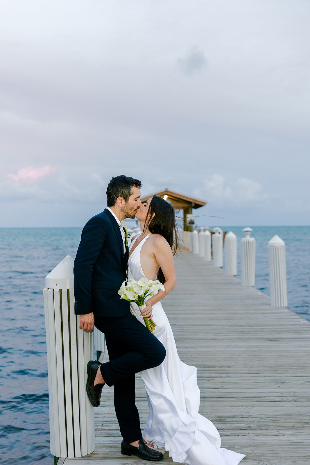 The newlyweds share a passionate kiss by the ocean at Casitas at Cheeca. Islamorada wedding photography by Claudia Amalia.