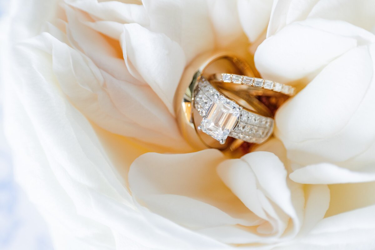 Details of wedding rings sitting together in a white flower