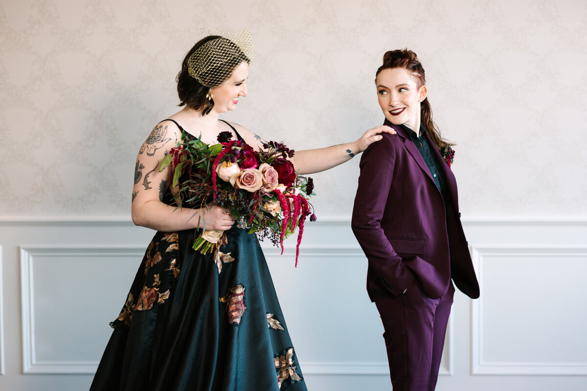 Two brides doing their first look in their gothic-style wedding attire
