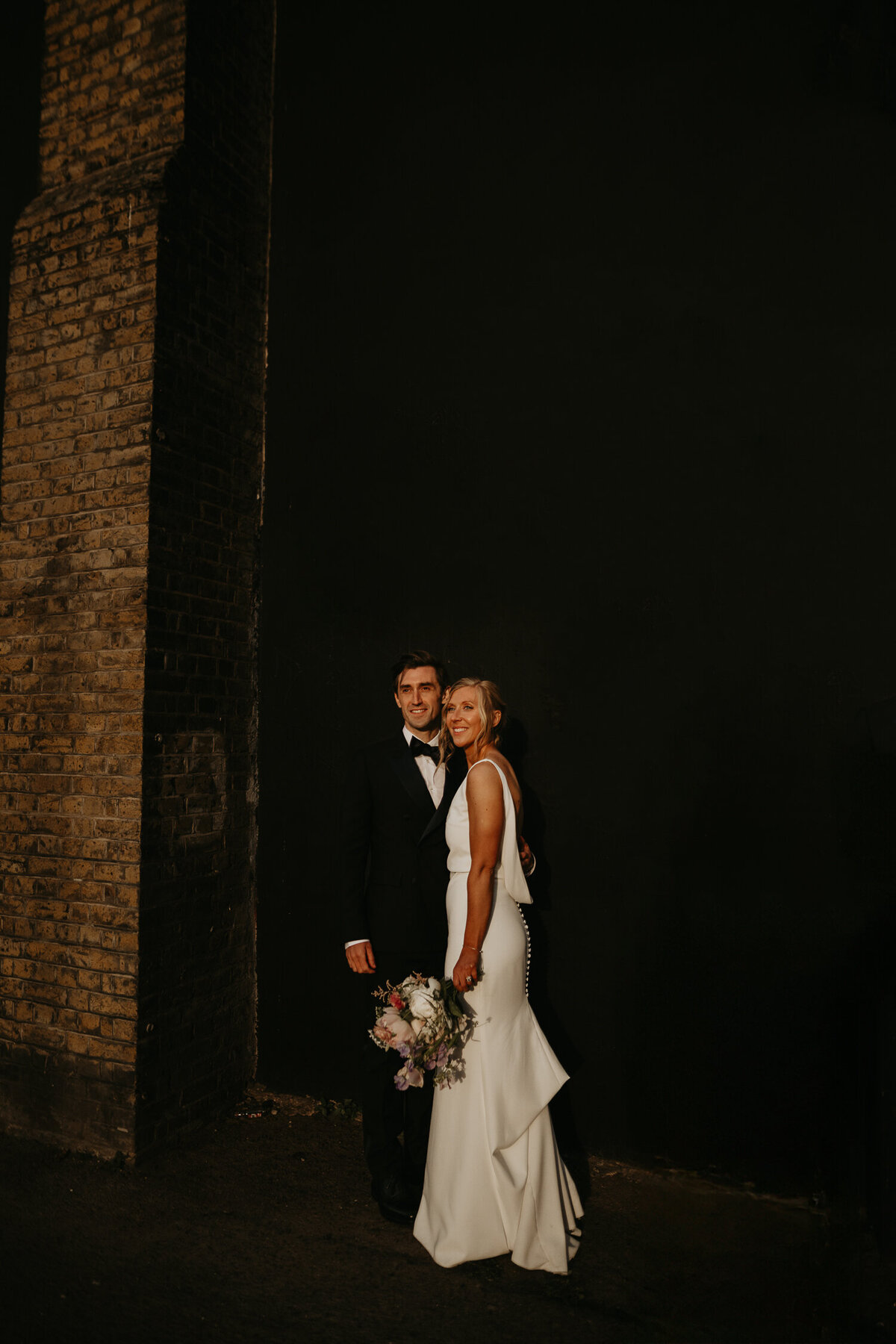 A bride and groom in the summer sun golden hour during their wedding portraits in London. 