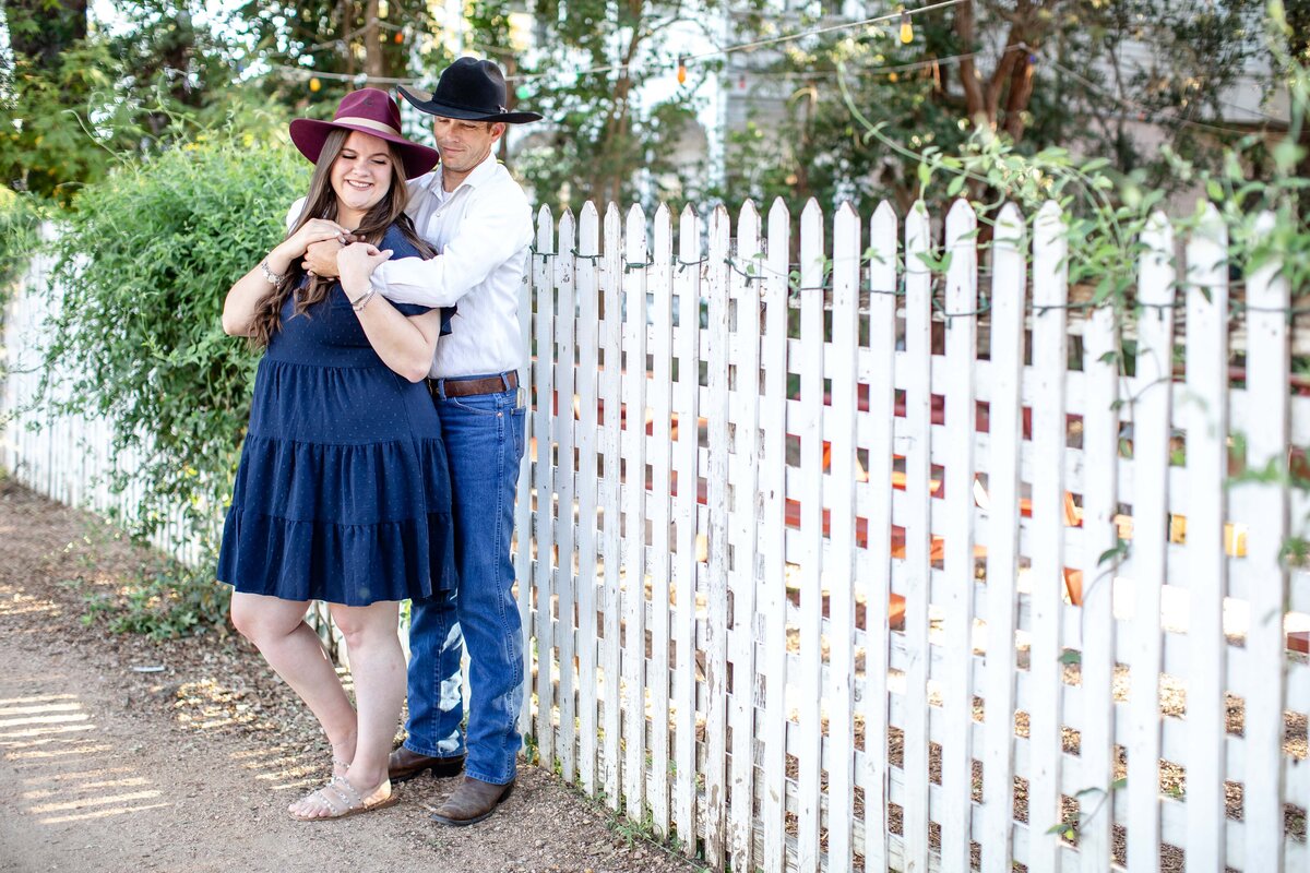 wedding photographer in Gruene Texas captures couple embracing at white picket fence